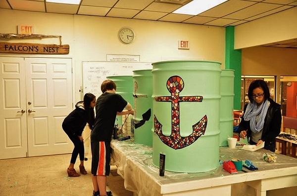 Teen artists work on trash barrels for Stage Fort Park at the Teen Artist Guild. 