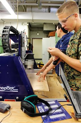 Seniors Michael Munroe and John Whitmore work with the CNC machine in Cabinet Making class