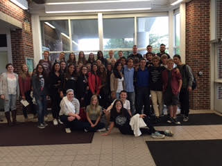 Exchange students and their hosts pose for a photo in the atrium