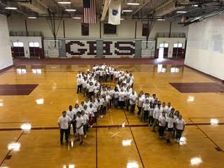 Students and staff pose for a group photo to show their support for breast cancer research