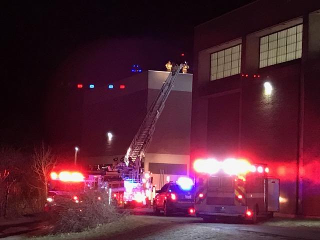 Fire officials stand on the roof of OMaley Innovation Middle School after flames began coming out of a vent.
