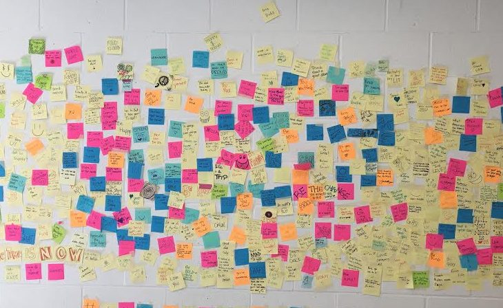 Students write positive messages on sticky notes to help boost student morale
