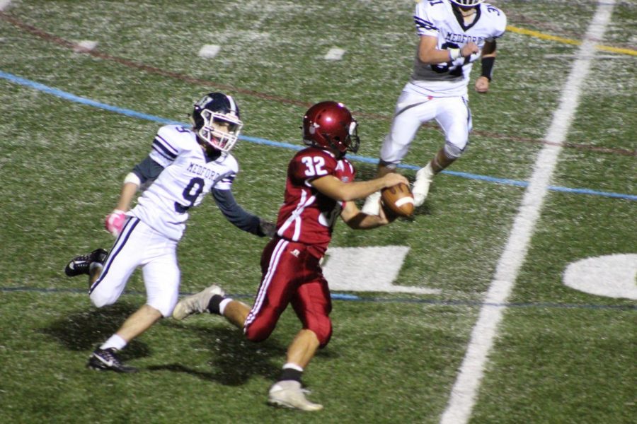 Marc Smith (32) attempts to throw as he is being rushed by a Medford player