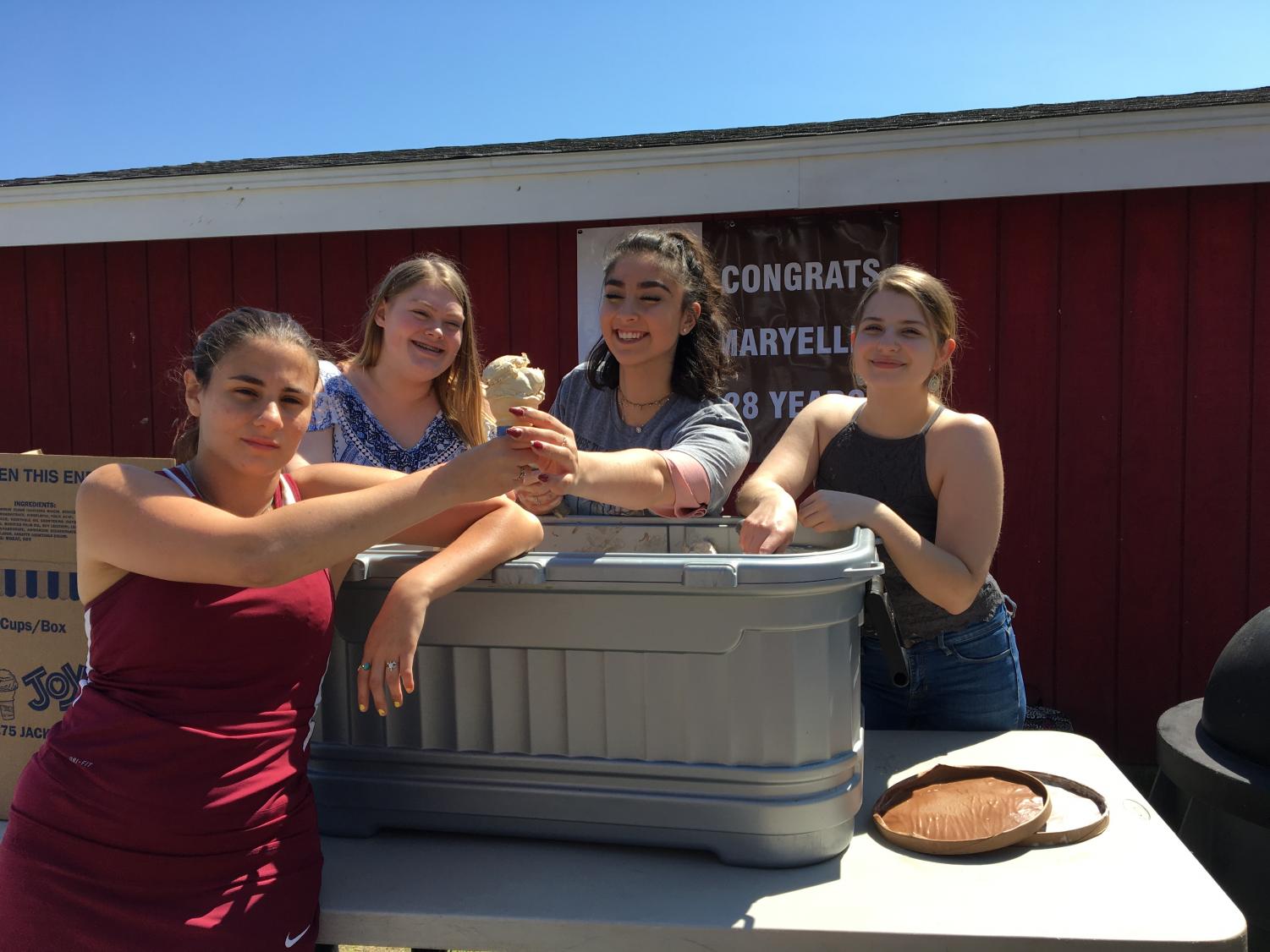 (from left) Allie Sears, Delaney Benchoff, and Rachel Belanger serve junior Tori Carini ice cream at Zielksi's retirement party