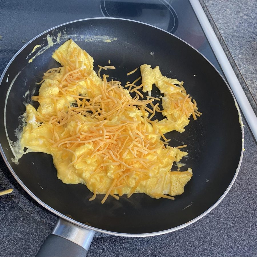 Adding shredded cheddar cheese to your scrambled eggs will enhance your breakfast experience