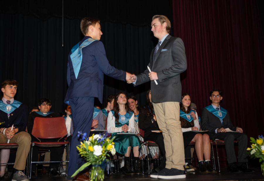 NHS+member+Kyle+Clifford+passes+his+candle+and+sash+on+to+Junior+Seamus+Buckley+as+NHS+members+and+new+inductees+watch.