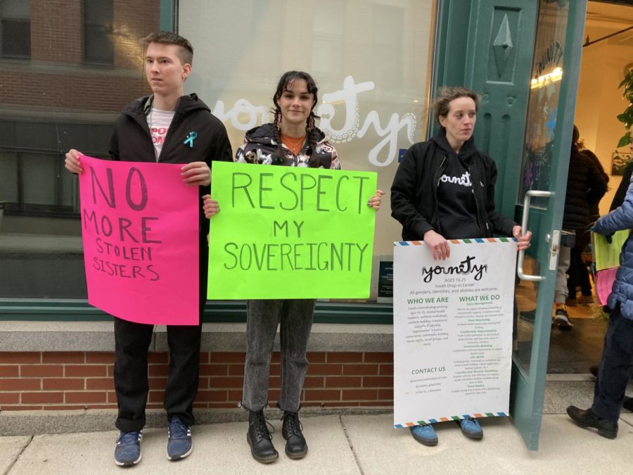 (from left) Liam Tate, Autumn Buhl, and Younity Program Director Kate Wise hold signs in support of Take Back the Night