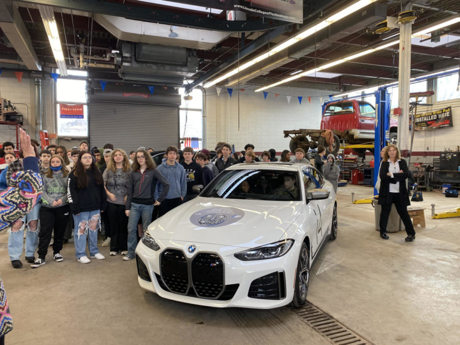 Rising ninth graders pose with all-electric BMW i4 showcased by the Lyon-Waugh Auto Group