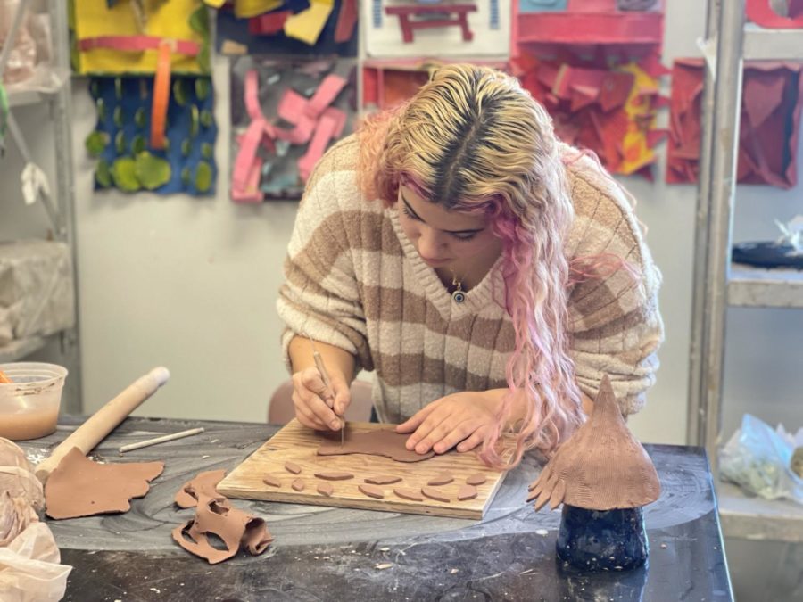 Marissa Numerosi carves pieces from a slab of clay