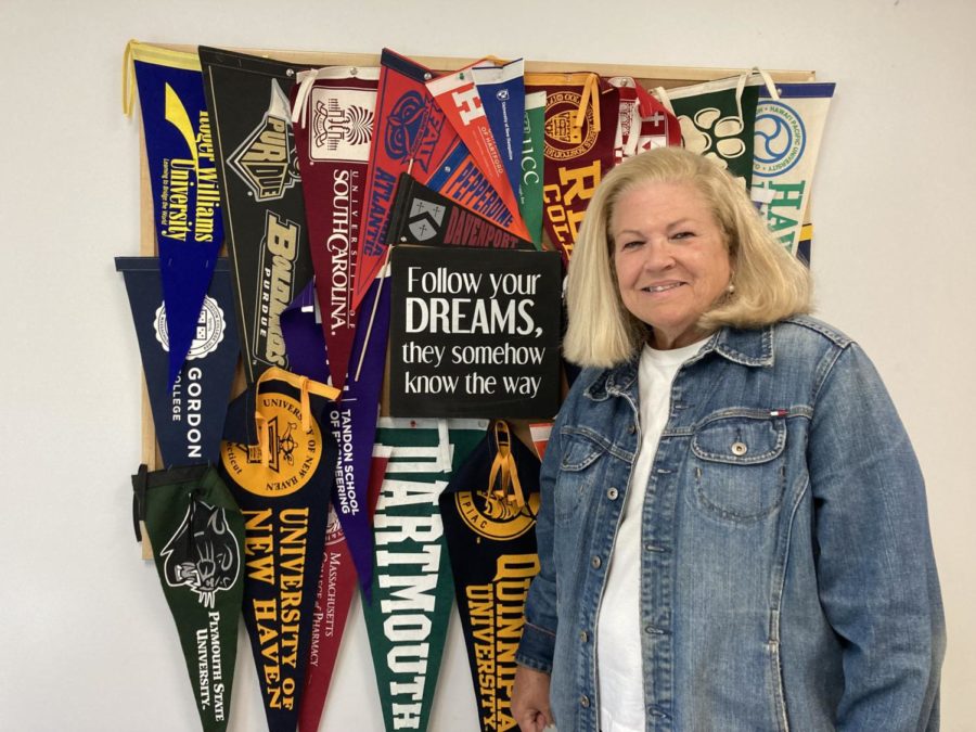 Ellen Clarke poses with her collection of college banners.