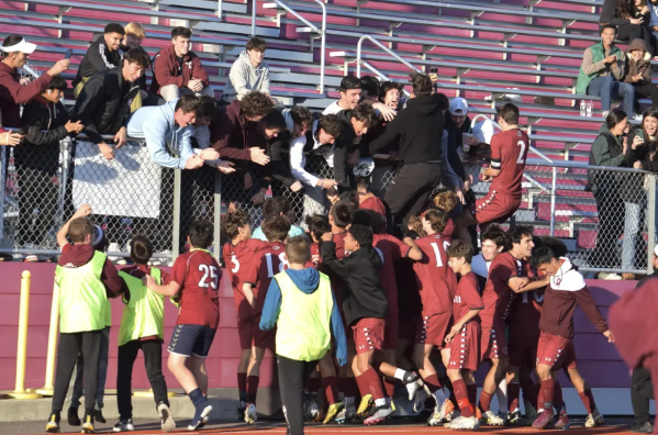 The GHS Boys Soccer Team, along with Ball Boys from the Gloucester Youth Soccer Team, jump into the student section after the shootout win. 