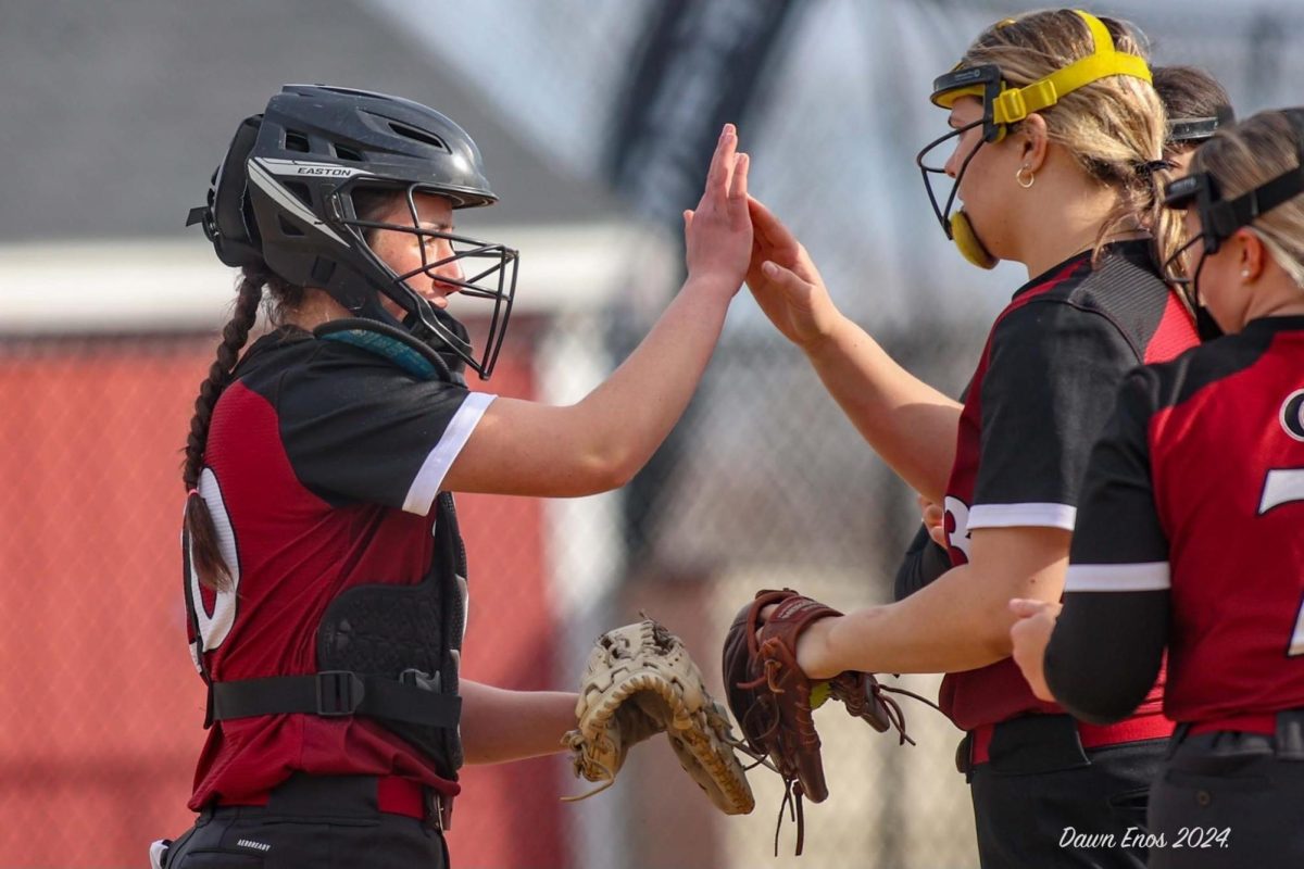 (From left to right) Olivia Madruga and Cam Carroll high five during the game.