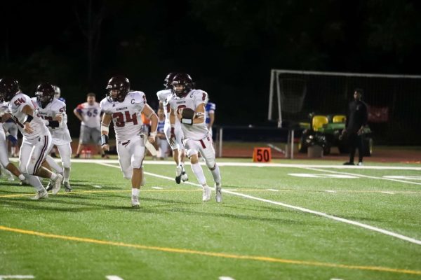 Jaylen Severino carries the ball with co-captain Thomas Cribbs as the lead blocker.
