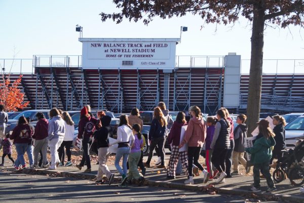 Students walk past Newell Stadium as they march from Gloucester High School to the boulevard. 