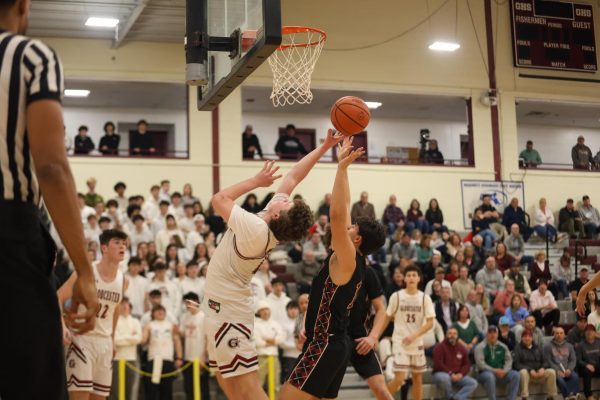 Senior Captain Andrew Cribbs goes for a layup after an offensive rebound. 