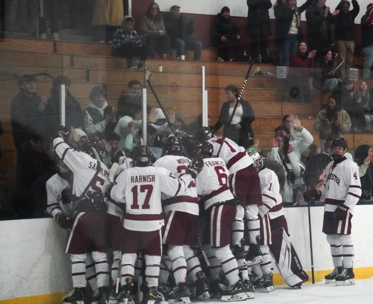 The Gloucester boys' hockey team celebrates Cade Cooper's game winning goal over the Masconomet Chieftains. 