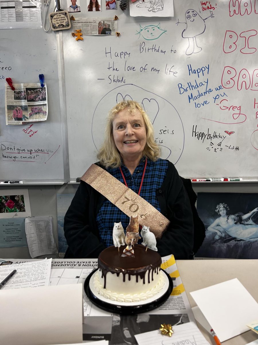 Madame Finacey smiles with her cat-themed birthday cake.