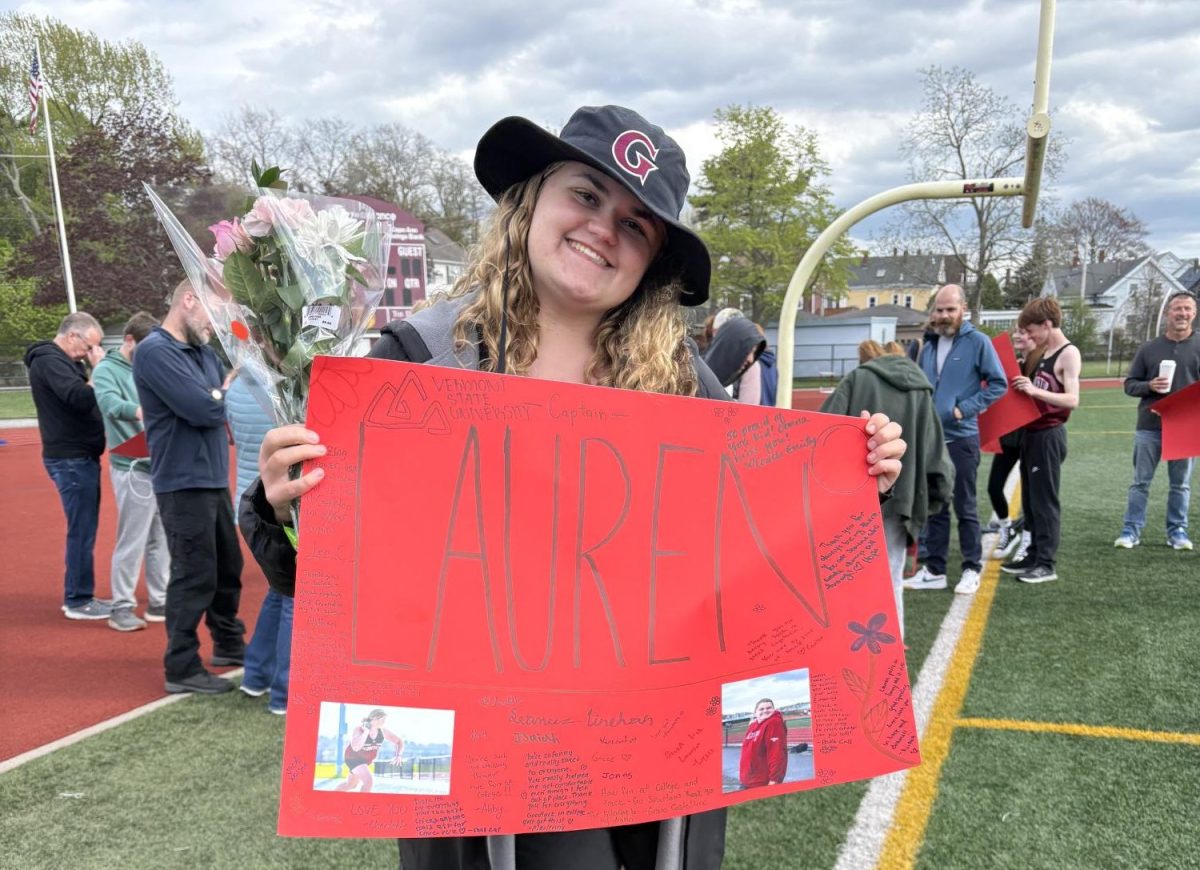 Lauren poses with her senior night banner during her track meet.