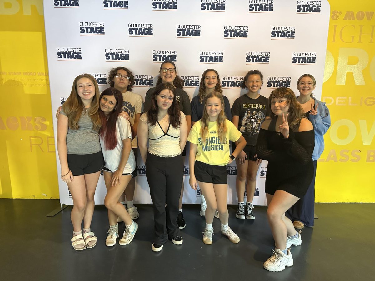 Student performers pose in front of Gloucester Stage backdrop.