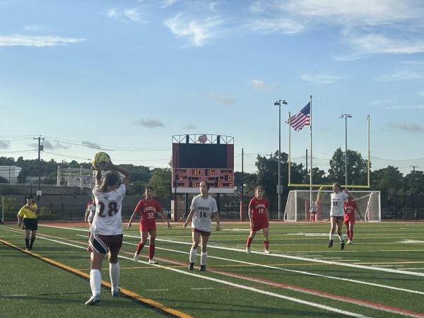 Gloucester soccer players stand on the pitch during their game.